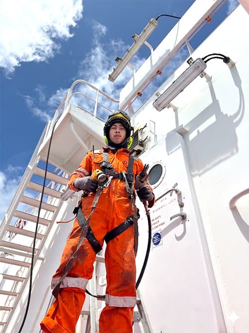 Cadet on watch at the bow of a merchant vessel