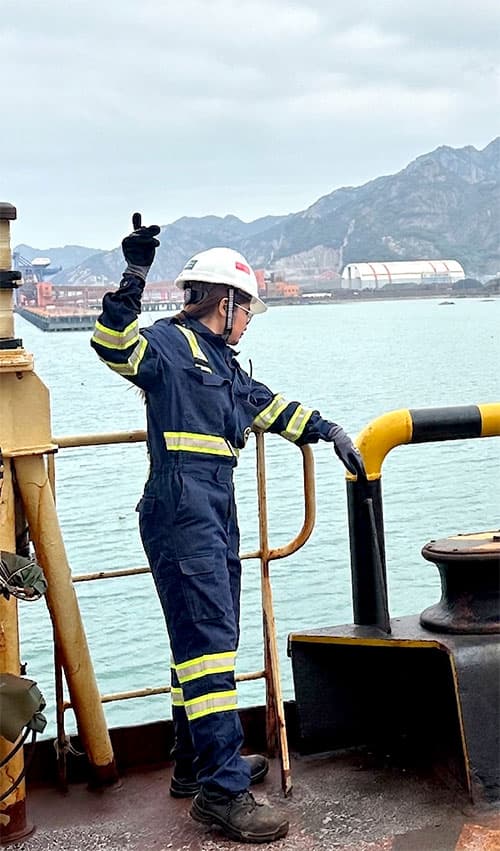 Cadet posing at a busy commercial port terminal