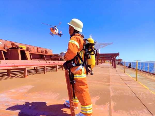 Crew member in safety gear on ship deck